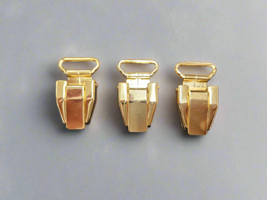 Drie goudkleurige dichte clips voor bretels van het merk Hein Strijker